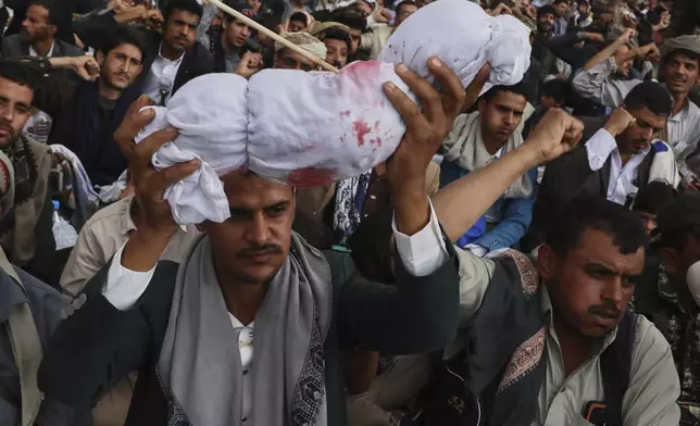 A Houthi supporter raises a symbolic bleeding coffin during Ashoura day, the Shiite Muslim commemoration marking the 7th-century death of Imam Hussein, the grandson of the Prophet Muhammad, in Sanaa, Yemen, Sunday, July 6, 2025. (AP Photo/Osamah Abdulrahman)