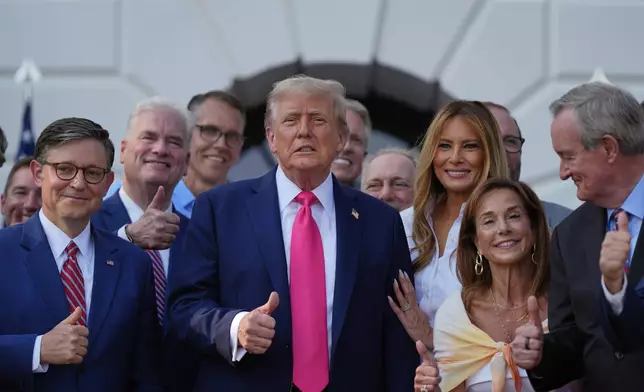 President Donald Trump poses for a photo after signing his signature bill of tax breaks and spending cuts at the White House, Friday, July 4, 2025, in Washington, surrounded by members of Congress, including House Speaker Mike Johnson of La., left. (AP Photo/Julia Demaree Nikhinson)