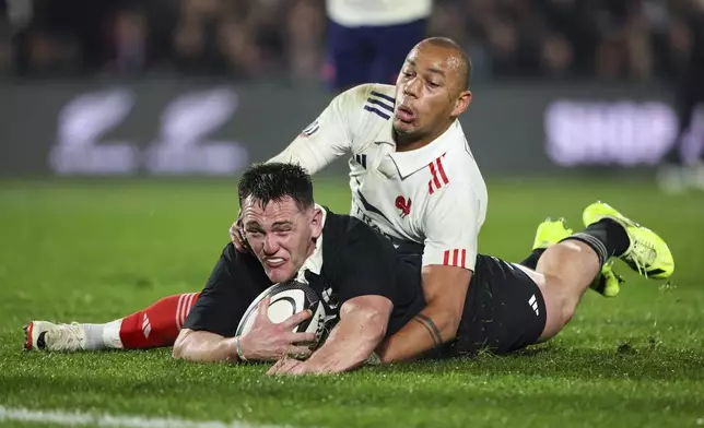 New Zealand's Brodie McAlister, left, scores a try despite the effort by France's Gael Fickou during their rugby union test match in Hamilton, New Zealand on Saturday, July 19, 2025. (Brett Phibbs/Photosport via AP)