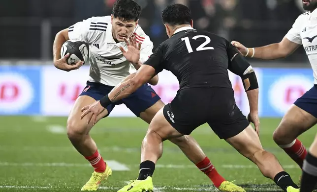 France's Gael Fickou, left, attempts to step around New Zealand's Quinn Tupaea during their rugby union test match in Hamilton, New Zealand on Saturday, July 19, 2025. (Jeremy Ward/Photosport via AP)