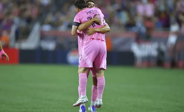 Inter Miami defender Jordi Alba, behind, lifts forward Lionel Messi (10) as they celebrate Messi's goal in the first half of an MLS soccer match against the New England Revolution, Wednesday, July 9, 2025, in Foxborough, Mass. (AP Photo/Steven Senne)