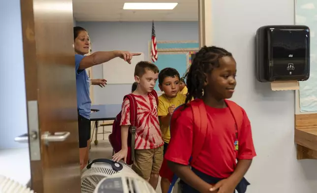 Kayla Creighton directs children to their next activity during the East Providence Boys and Girls Club Summer Camp at Emma G. Whiteknact Elementary School on Thursday, July 10, 2025, in Providence, R.I. (AP Photo/Sophie Park)