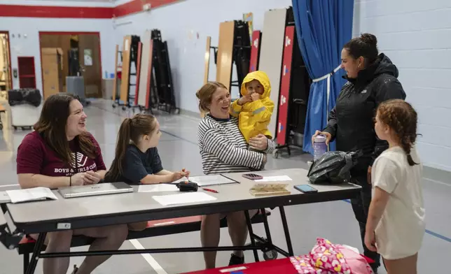 A parent drops their children off at the East Providence Boys and Girls Club Summer Camp at Emma G. Whiteknact Elementary School on Thursday, July 10, 2025, in Providence R.I. (AP Photo/Sophie Park)