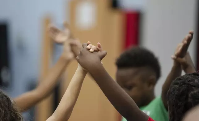 Children hold hands while participating in activities during the East Providence Boys and Girls Club Summer Camp at Emma G. Whiteknact Elementary School on Thursday, July 10, 2025, in Providence R.I. (AP Photo/Sophie Park)