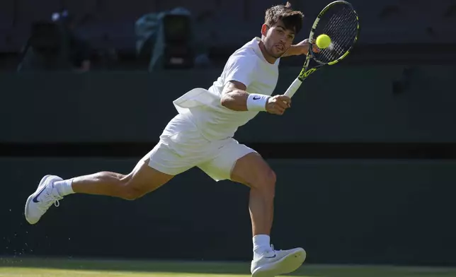 Spain's Carlos Alcaraz returns to Britain's Cameron Norrie during a quarterfinal men's singles match at the Wimbledon Tennis Championships in London, Tuesday, July 8, 2025. (AP Photo/Kirsty Wigglesworth)