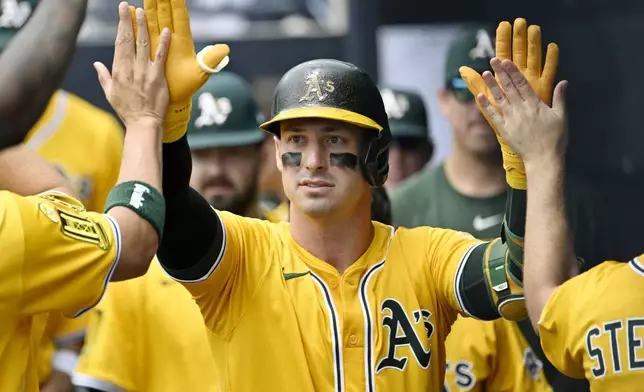 Athletics' Brent Rooker is greeted in the dugout after hitting a solo home run in the first inning of a baseball game against the Tampa Bay Rays, Wednesday, July 2, 2025, in Tampa, Fla. (AP Photo/Jason Behnken)
