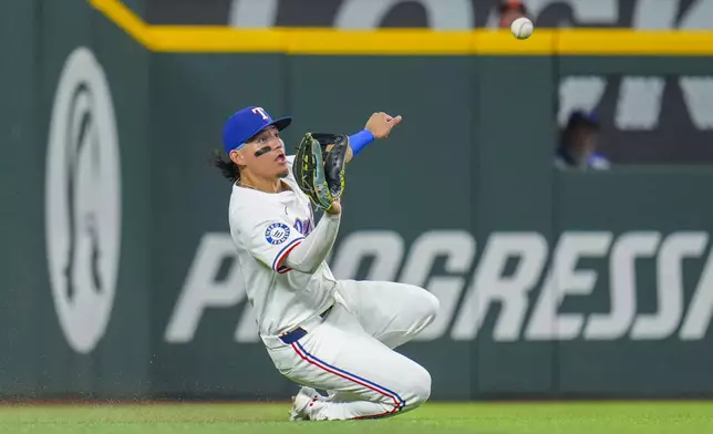 Texas Rangers outfielder Alejandro Osuna makes a sliding catch on a ball hit by Baltimore Orioles' Ryan O'Hearn during the fourth inning of a baseball game Tuesday, July 1, 2025, in Arlington, Texas. (AP Photo/Julio Cortez)
