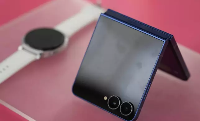 The new Galaxy Z Flip 7 and a smart watch are displayed during a Samsung preview event in New York, Monday, July 7, 2025. (AP Photo/Seth Wenig)