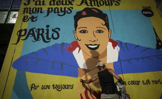 Artist Franck Duval, aka FKDL, works on a mural of U.S.-French entertainer and civil rights activist Josephine Baker in Paris, Saturday, July 19, 2025. (AP Photo/Thomas Padilla)