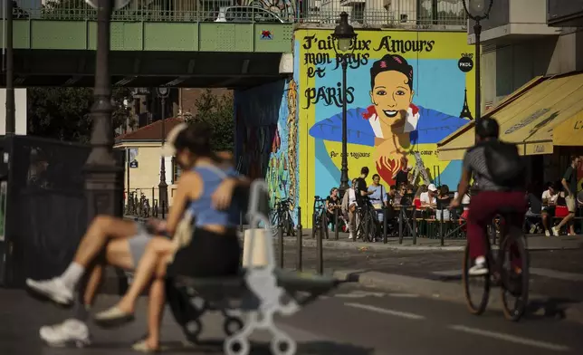 Artist Franck Duval, aka FKDL, works on a mural of U.S.-French entertainer and civil rights activist Josephine Baker in Paris, Saturday, July 19, 2025. (AP Photo/Thomas Padilla)