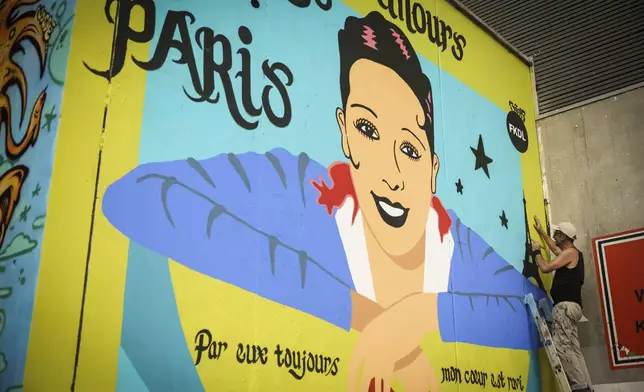 Artist Franck Duval, aka FKDL, works on a mural of U.S.-French entertainer and civil rights activist Josephine Baker in Paris, Saturday, July 19, 2025. (AP Photo/Thomas Padilla)