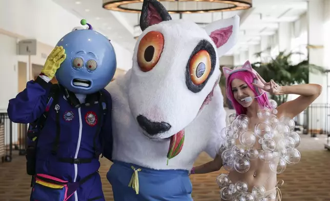 Javier Lovato of Los Angeles dressed as Time Traveler Todd, from left, Mitchell Walter of Los Angeles dressed as Bullet, and Emily La Rue of Los Angeles dressed as Kat from "Bullet Time" attend Comic-Con International on Saturday, July 26, 2025, in San Diego. (Photo by Andrew Park/Invision/AP)