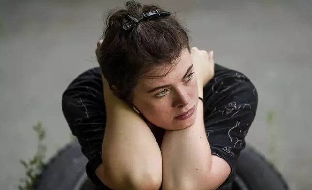 A woman sits near her residential house damaged by a Russian strike in Kyiv, Ukraine, Friday, July 4, 2025. (AP Photo/Evgeniy Maloletka)