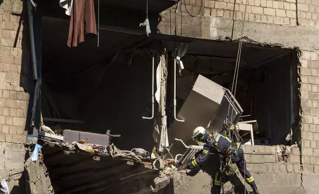 Rescue workers clear the rubble of a residential house damaged by a Russian strike in Kyiv, Ukraine, on Friday, July 4, 2025. (AP Photo/Evgeniy Maloletka)