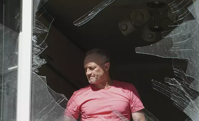 A man looks at broken window in his house after a Russian drone and missile attack in Kyiv, Ukraine, Friday, July 4, 2025. (AP Photo/Efrem Lukatsky)