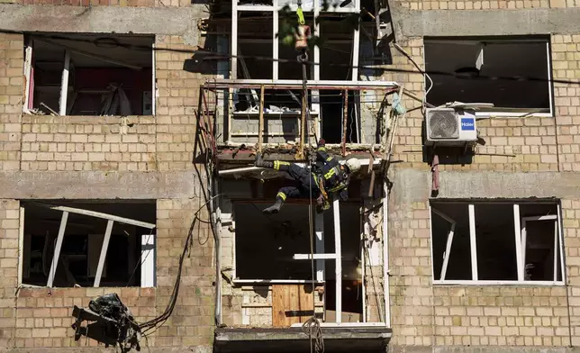 A rescue worker clears the rubble of a residential house damaged by a Russian strike in Kyiv, Ukraine, on Friday, July 4, 2025. (AP Photo/Evgeniy Maloletka)