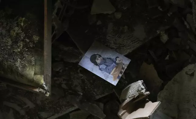 A photo of a child is seen amid the rubble of a destroyed building following an Israeli strike, in Tehran, Iran, Wednesday, June 25, 2025. (AP Photo/Vahid Salemi)