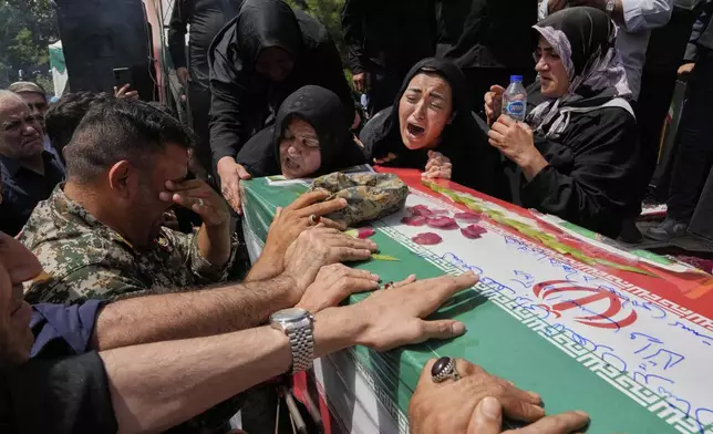 Relatives mourn over the flag-draped coffin of Mahan Setareh, a member of the paramilitary Basij force who was killed in Israeli attacks, during his funeral ceremony in Tehran, Iran, Thursday, June 26, 2025. (AP Photo/Vahid Salemi)