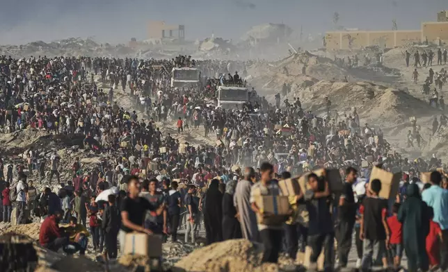 Palestinians carry sacks and boxes of food and humanitarian aid, unloaded from a World Food Program convoy that was heading to Gaza City in the northern Gaza Strip, Monday, June 16, 2025. (AP Photo/Jehad Alshrafi)