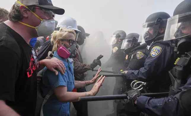 Protesters confront police on the 101 Freeway near the Metropolitan Detention Center of downtown Los Angeles, Sunday, June 8, 2025, following last night's immigration raid protest. (AP Photo/Jae C. Hong)