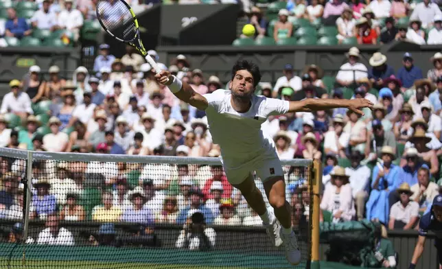 Carlos Alcaraz of Spain returns the ball to Taylor Fritz of the U.S. during the men's semifinal singles match at the Wimbledon Tennis Championships in London, Friday, July 11, 2025.(AP Photo/Joanna Chan)
