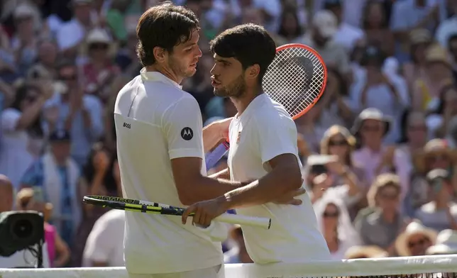 Spain's Carlos Alcaraz, right, greets Taylor Fritz of the U.S. after beating him in a men's singles semifinal at the Wimbledon Tennis Championships in London, Friday, July 11, 2025. (AP Photo/Kin Cheung)