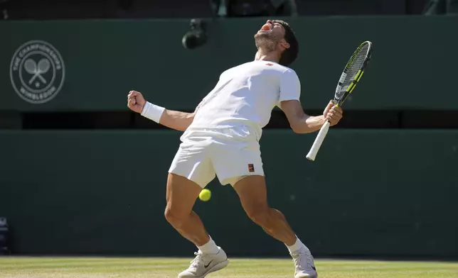 Spain's Carlos Alcaraz celebrates after beating Taylor Fritz of the U.S. in a men's singles semifinal at the Wimbledon Tennis Championships in London, Friday, July 11, 2025. (AP Photo/Kin Cheung)