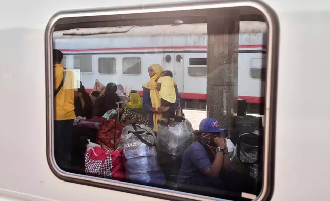 A Sudanese woman and children, who were driven from their homes and are now returning, wait for their train to Aswan at Cairo's Ramses railway station, Egypt, Monday, July 21, 2025. (AP Photo/Amr Nabil)