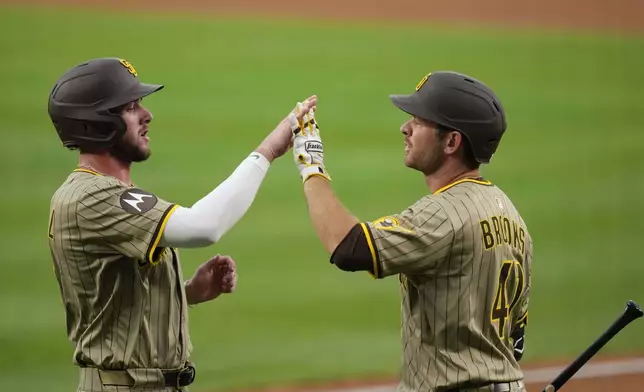 San Diego Padres' Jackson Merrill, left, high fives Trenton Brooks (41) after scoring against the Washington Nationals on a ball hit by Jake Cronenworth during the second inning of a baseball game at Nationals Park, Friday, July 18, 2025, in Washington. (AP Photo/Jess Rapfogel)