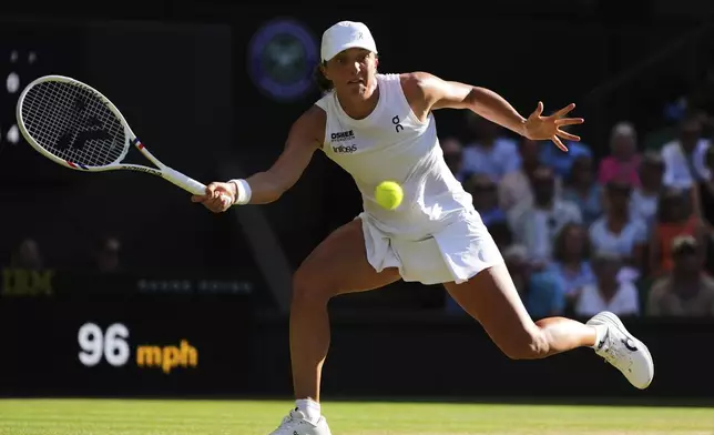 Iga Swiatek of Poland returns to Belinda Bencic of Switzerland during the women's singles semifinal match at the Wimbledon Tennis Championships in London, Thursday, July 10, 2025.(AP Photo/Kirsty Wigglesworth)