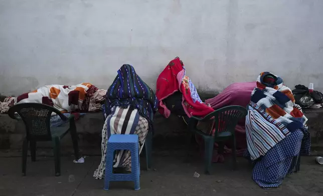 Residents remain outside their homes after dozens of earthquakes and aftershocks were recorded in a matter of hours in Palin, Guatemala, early Wednesday, July 9, 2025. (AP Photo/Moises Castillo)