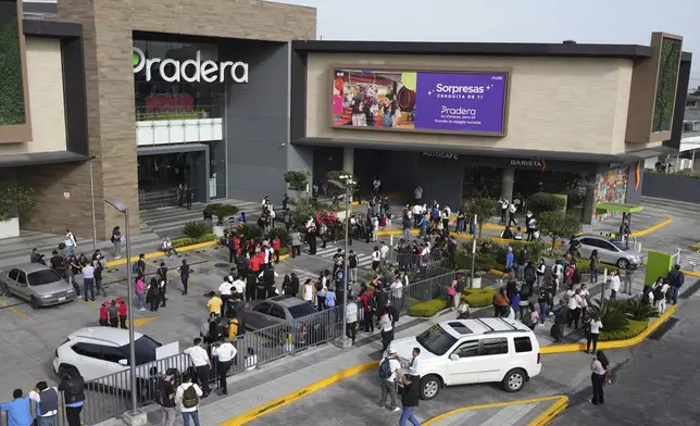 People gather outside of a shopping mall after an earthquake in Guatemala City, Tuesday, July 8, 2025. (AP Photo/Moises Castillo)