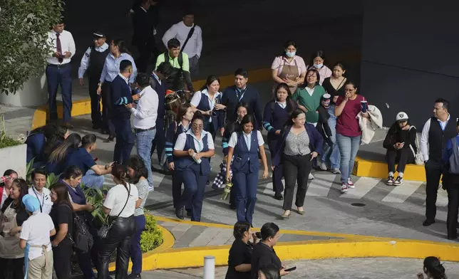 People gather outside of a shopping mall after an earthquake in Guatemala City, Tuesday, July 8, 2025. (AP Photo/Moises Castillo)