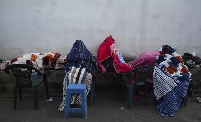 Neighbors remain outside their home in Palin, Guatemala, Wednesday, July 9, 2025, After a series of earthquakes with magnitudes ranging from 3.0 to 5.6, according to authorities. (AP Photo/Moises Castillo)