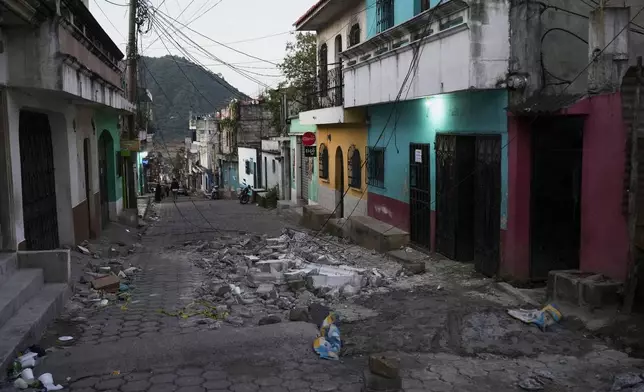 Debris from a damaged house on the street in Palin, Guatemala, Wednesday, July 9, 2025, After a series of earthquakes with magnitudes ranging from 3.0 to 5.6, according to authorities. (AP Photo/Moises Castillo)