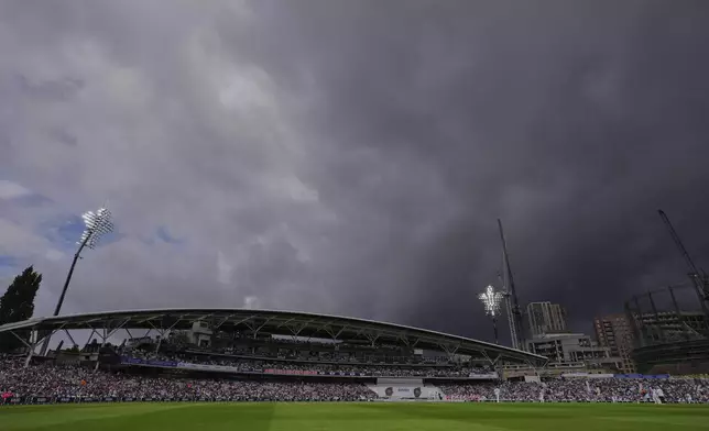 Dark clouds hover over the sky as flood lights on during the first day of the fifth cricket test match between England and India at The Kia Oval in London, Thursday, July 31, 2025. (AP Photo/Kirsty Wigglesworth)