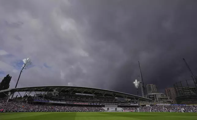 Dark clouds hover over the sky as flood lights on during the first day of the fifth cricket test match between England and India at The Kia Oval in London, Thursday, July 31, 2025. (AP Photo/Kirsty Wigglesworth)