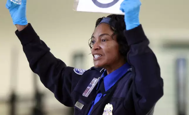 FILE - A TSA employee advises travelers that liquids are not allowed through the gate at at the Los Angeles International Airport, Oct. 10, 2012. (AP Photo/Damian Dovarganes, File)
