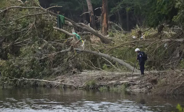 Search and rescue teams comb the banks of the Guadalupe River after a flash flood swept through the area, Saturday, July 12, 2025, in Kerrville, Texas. (AP Photo/Eric Gay)