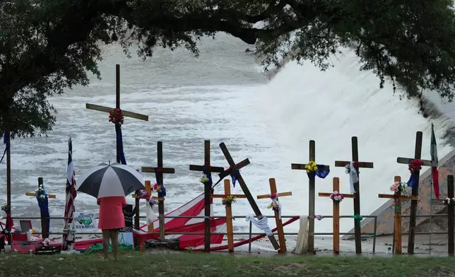Rain falls over a makeshift memorial for flood victims along the Guadalupe River, Sunday, July 13, 2025, in Kerrville, Texas. (AP Photo/Eric Gay)