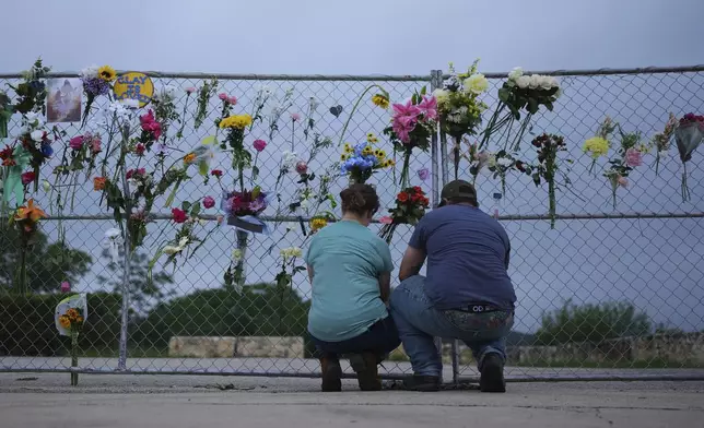 Visitors place items on a memorial wall for flood victims, Sunday, July 13, 2025, in Kerrville, Texas. (AP Photo/Eric Gay)