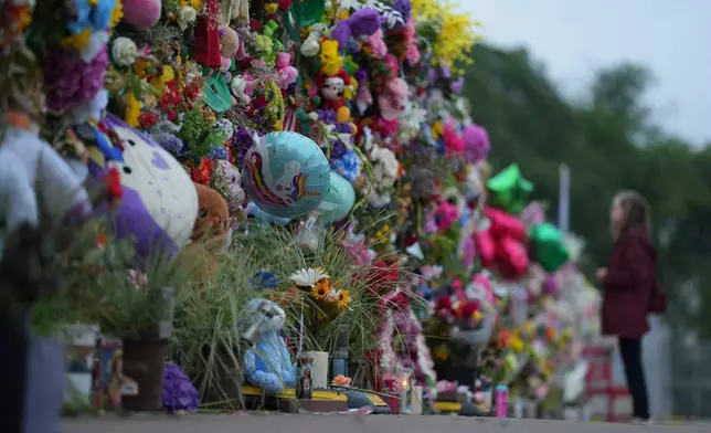 A visitor views a memorial wall for flood victims, Sunday, July 13, 2025, in Kerrville, Texas. (AP Photo/Eric Gay)