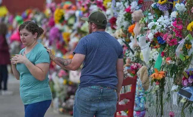 Visitors view a memorial wall for flood victims, Sunday, July 13, 2025, in Kerrville, Texas. (AP Photo/Eric Gay)