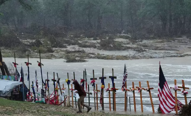 Rain falls over a makeshift memorial for flood victims along the Guadalupe River, Sunday, July 13, 2025, in Kerrville, Texas. (AP Photo/Eric Gay)
