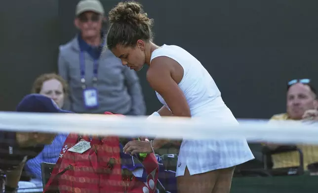 Jasmine Paolini of Italy packs up to leave the court after losing to Russia's Kamilla Rakhimova during their second round women's singles match at the Wimbledon Tennis Championships in London, Wednesday, July 2, 2025. (AP Photo/Joanna Chan)