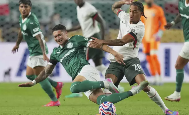 Palmeiras' Emiliano Martinez, left, falls challenged by Chelsea's Joao Pedro during the Club World Cup quarterfinal soccer match between Palmeiras and Chelsea in Philadelphia, Friday, July 4, 2025. (AP Photo/Chris Szagola)