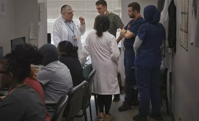 A group of resident doctors talks with a senior doctor inside Brookdale University Hospital and Medical Center on Tuesday, July 1, 2025, in the Brooklyn borough of New York. (AP Photo/Andres Kudacki)