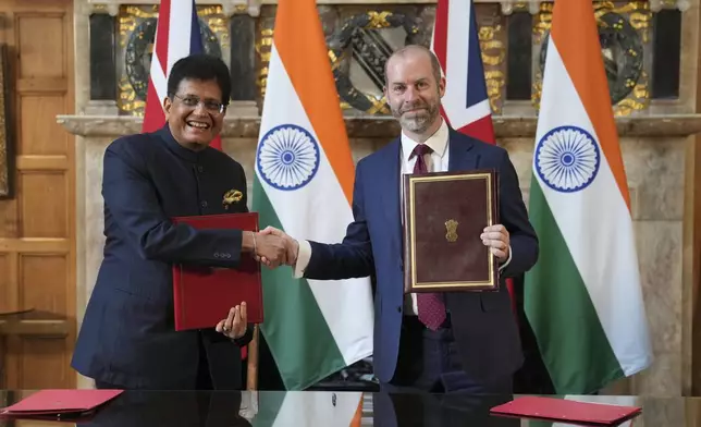 Britain's Secretary of State for Business and Trade, Jonathan Reynolds, right, and Piyush Goyal, Minister of Industry and Supply of India, shake hands after they signed a free trade agreement at Chequers near Aylesbury, England, Thursday, July 24, 2025.(AP Photo/Kin Cheung, Pool)