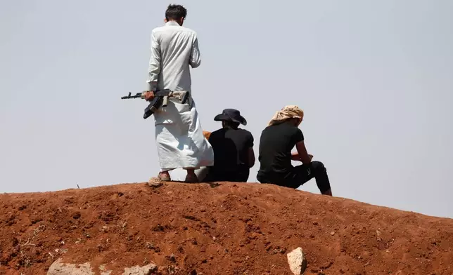 Bedouin fighters gather as Syrian government security forces block them from entering Sweida province, in Busra al-Harir village, southern Syria, Sunday, July 20, 2025. (AP Photo/Omar Sanadiki)