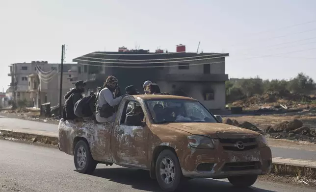 Bedouin fighters ride in a truck in Mazraa village on the outskirts of Sweida city, in southern Syria, Saturday, July 19, 2025. (AP Photo/Ghaith Alsayed)